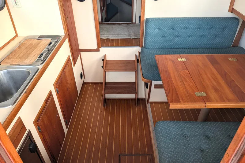 Slide: The Image of Interior of a 1995 Nordic Tug 26 with wooden flooring and seating area. - 11