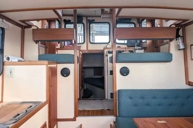 Slide: The Image of Interior of a 1995 Nordic Tug 26, featuring wood accents and seating area. - 12