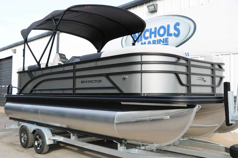 Slide: The Image of 2027 Bennington 22 S1SSR Tri Toon on a trailer, featuring a black canopy and sleek lines. - 6