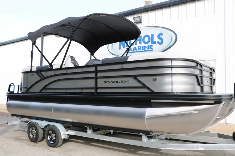 Slide: The Image of 2027 Bennington 22 S1SSR Tri Toon on a trailer, featuring a black sunshade. - 5