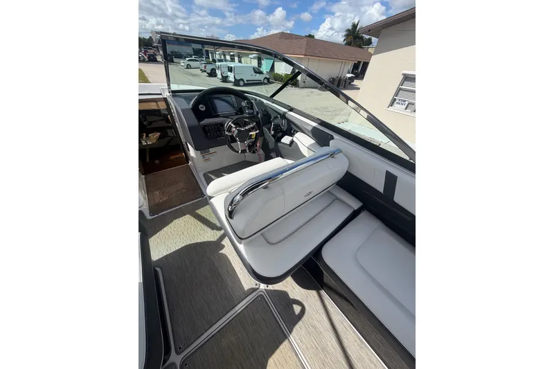 Slide: The Image of 2017 Regal 29 OBX boat interior with steering wheel and seating, under sunny skies. - 17