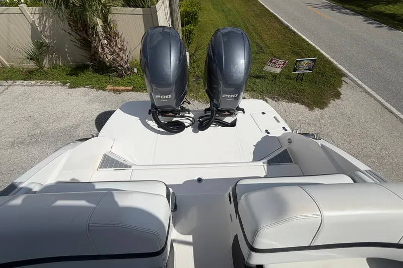 Slide: The Image of 2017 Regal 29 OBX boat with dual 200 horsepower outboard engines, parked near a road. - 29