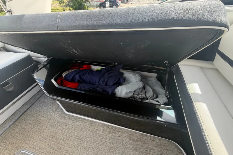Slide: The Image of Open storage compartment on 2017 Regal 29 OBX boat with clothes inside. - 26