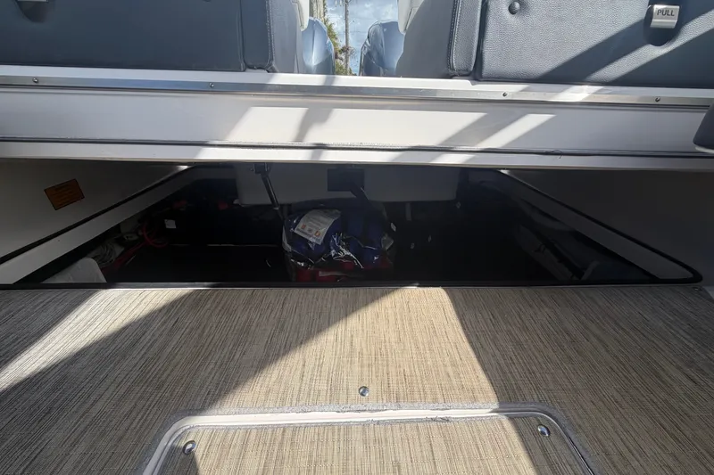 Slide: The Image of 2017 Regal 29 OBX boat storage compartment with open hatch, revealing interior equipment. - 28