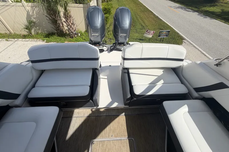 Slide: The Image of 2017 Regal 29 OBX boat interior with white seating and dual outboard engines. - 24