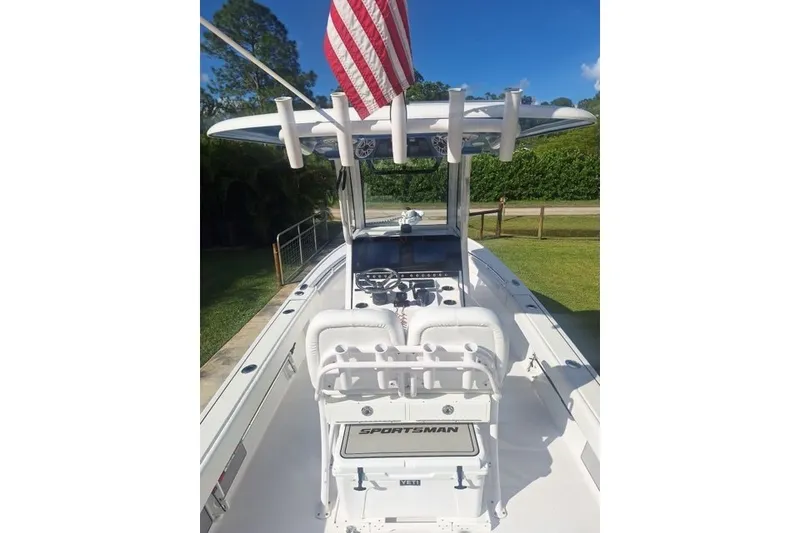 Slide: The Image of 2022 Sportsman Masters 247OE Bay Boat with American flag, sleek design, and modern console. - 5