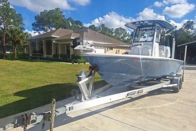 Slide: The Image of 2022 Sportsman Masters 247OE Bay Boat on trailer, parked in residential driveway. - 1