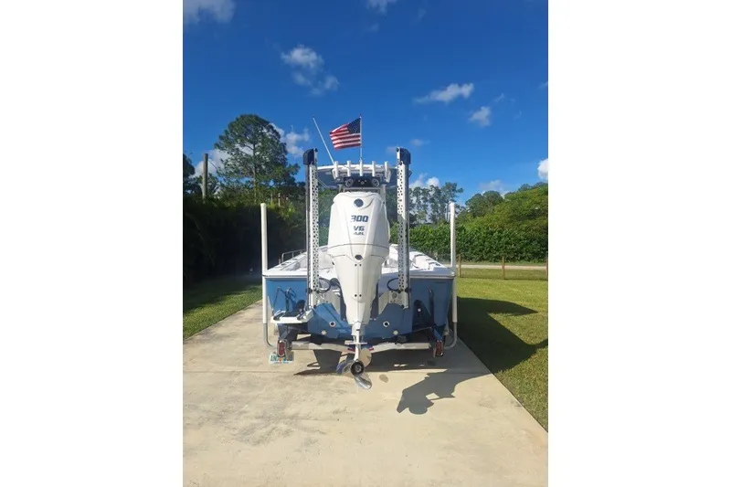 Slide: The Image of 2022 Sportsman Masters 247OE Bay Boat with outboard motor, parked on driveway. - 2