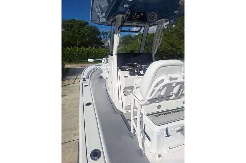 Slide: The Image of 2022 Sportsman Masters 247OE Bay Boat with white seating and console, docked outdoors. - 6
