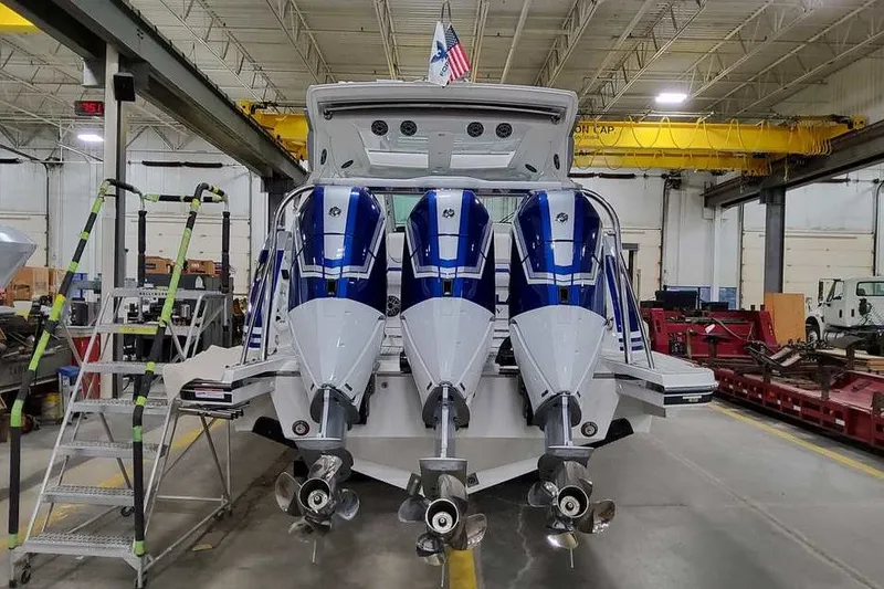 Slide: The Image of 2027 Formula 360 Super Sport Crossover boat with triple outboard engines in a workshop. - 11