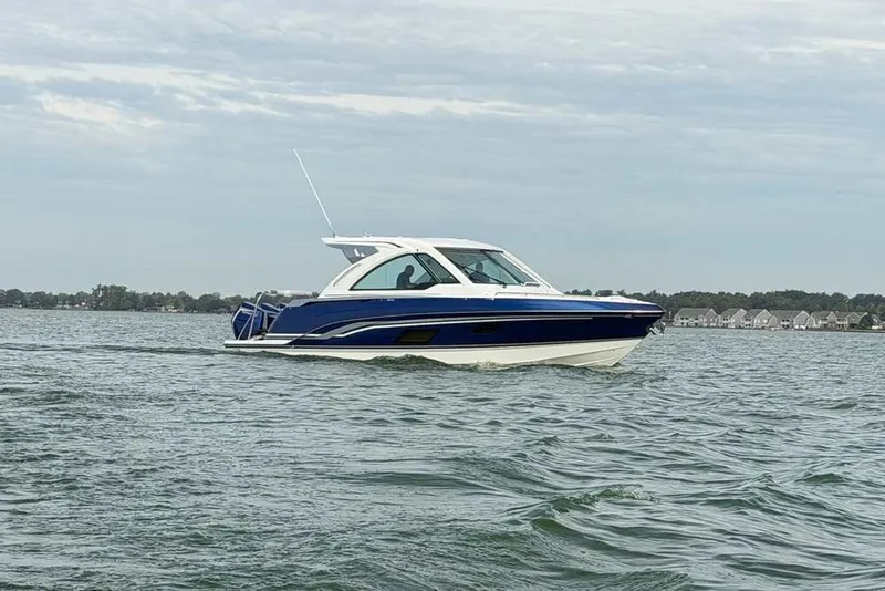 Slide: The Image of 2027 Formula 360 Super Sport Crossover boat cruising on a lake under cloudy skies. - 3