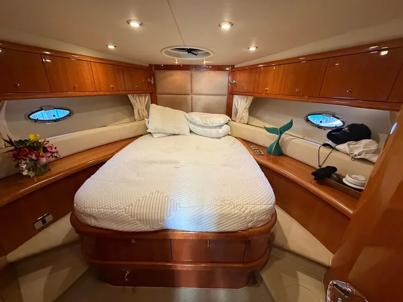 Slide: The Image of Luxurious cabin with a double bed, wooden furnishings, and porthole windows. - 11