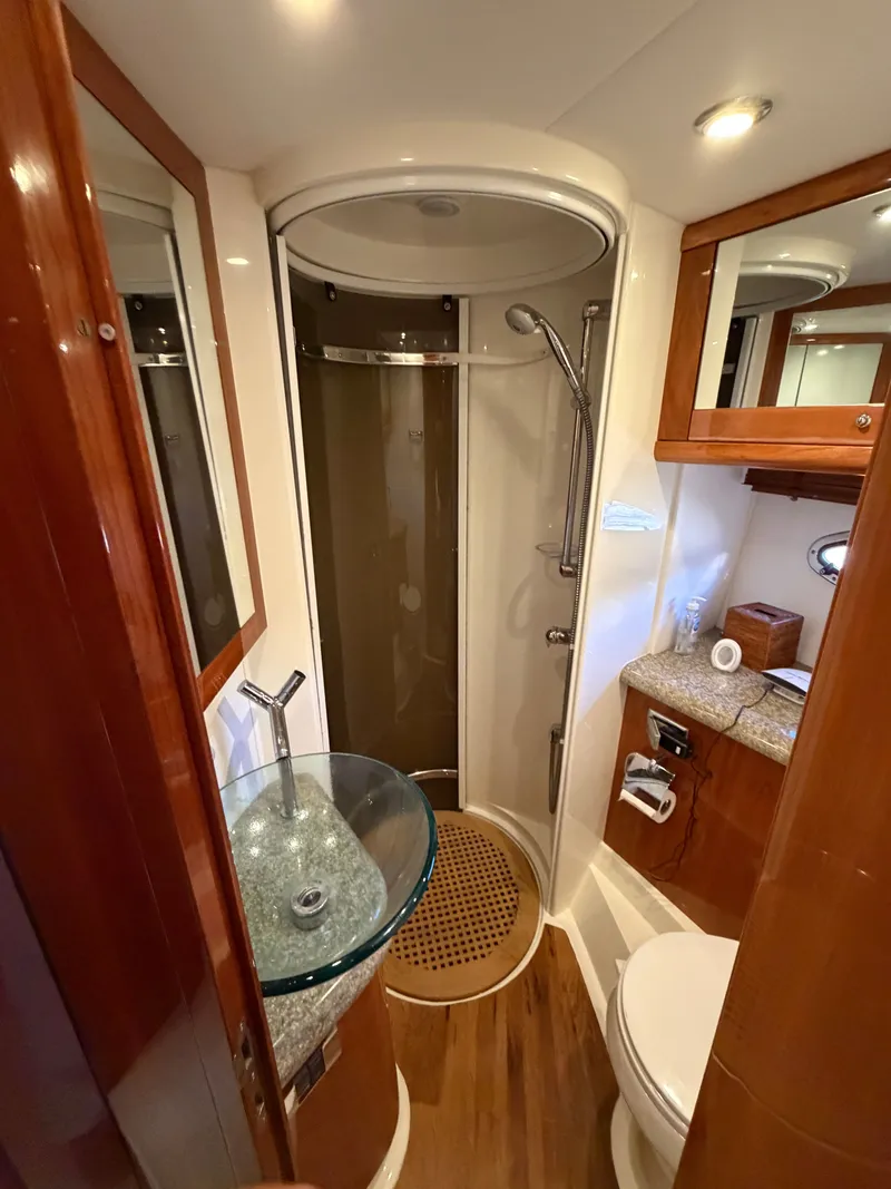 Slide: The Image of Luxurious bathroom with glass sink, shower, and toilet in a Sunseeker Portofino 46 yacht. - 14