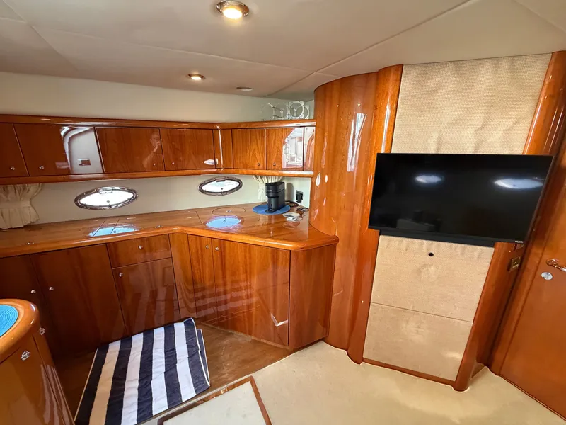 Slide: The Image of Luxurious interior of a Sunseeker Portofino 46 with glossy wood cabinetry and a flat-screen TV. - 18