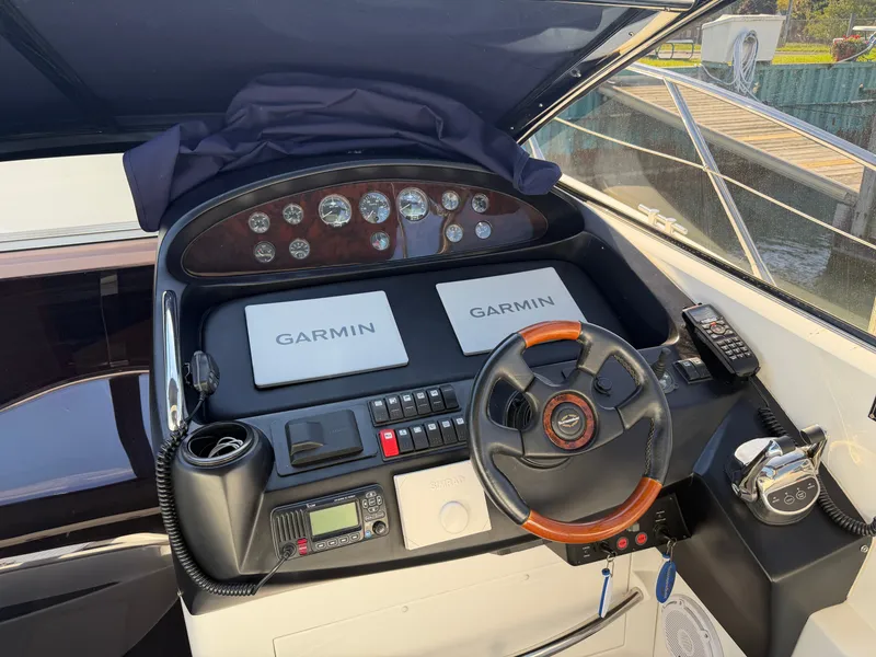 Slide: The Image of The cockpit of a Sunseeker Portofino 46 with modern Garmin devices and a sleek steering wheel. - 9