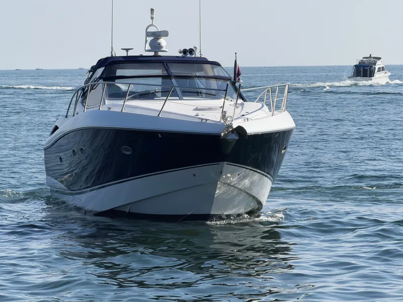 Slide: The Image of A 2006 Sunseeker Portofino 46 cruising on calm waters, with another boat in the background. - 5