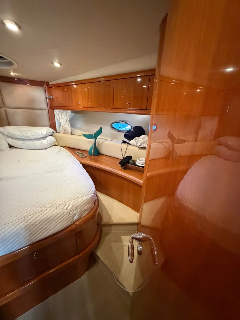 Slide: The Image of Luxurious cabin with double bed, wooden furnishings, and porthole on a Sunseeker Portofino 46. - 12