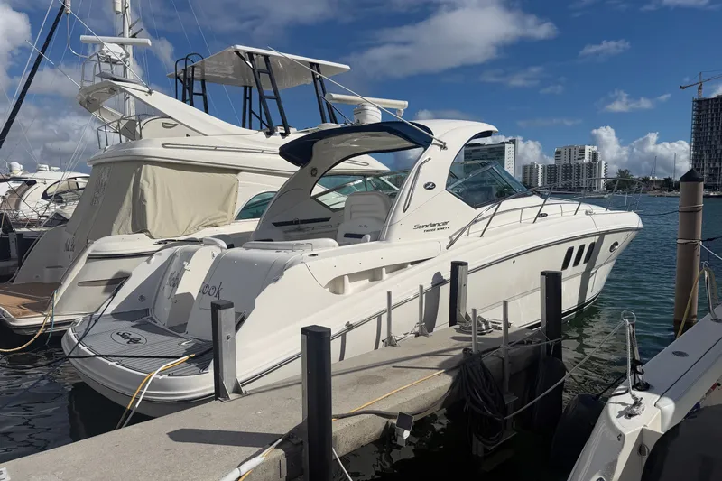 Slide: The Image of 2010 Sea Ray 390 Sundancer yacht docked at marina under clear blue sky. - 2