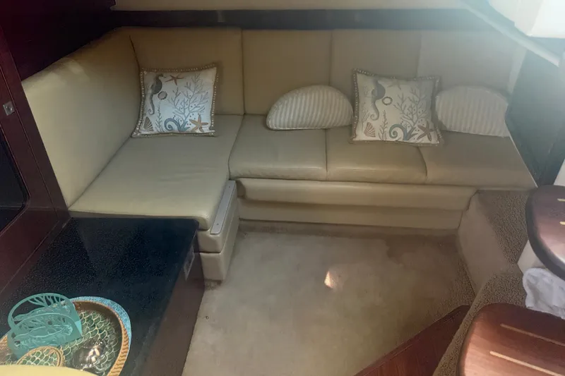 Slide: The Image of Interior of 2010 Sea Ray 390 Sundancer with beige leather seating and decorative pillows. - 16