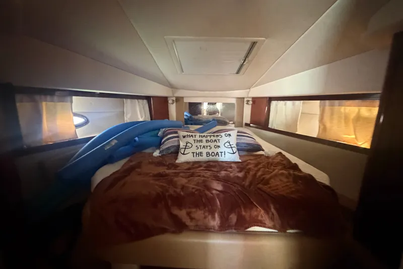 Slide: The Image of Cozy cabin interior of 2010 Sea Ray 390 Sundancer with humorous pillow on bed. - 13