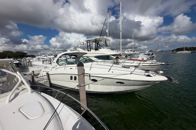 The Image of 2010 Sea Ray 390 Sundancer yacht docked at marina under cloudy sky. - 0