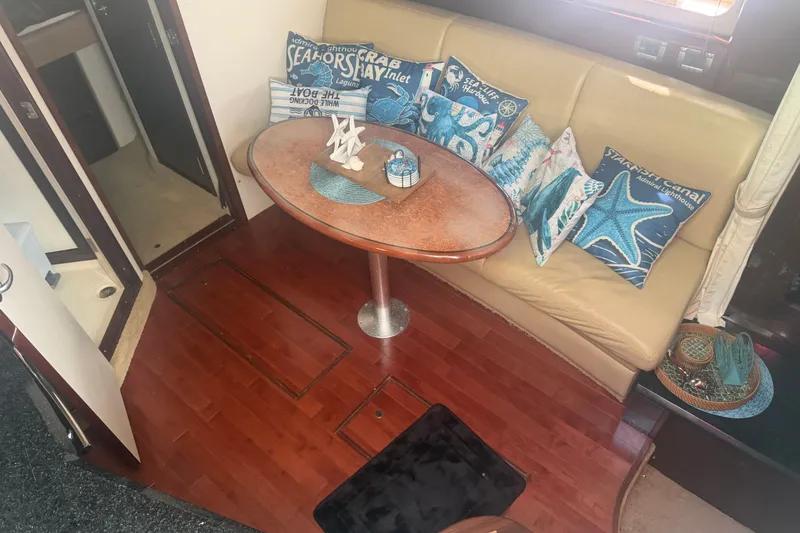 Slide: The Image of Interior of 2010 Sea Ray 390 Sundancer with cozy seating and nautical-themed decor. - 8