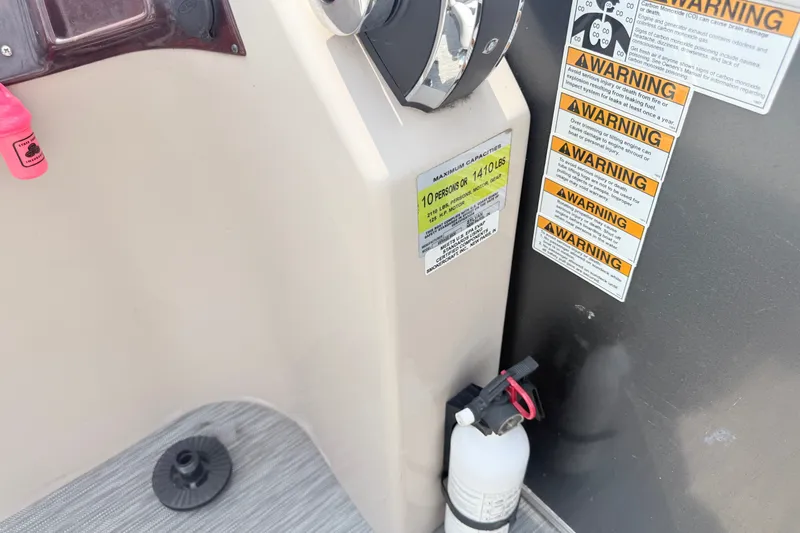 Slide: The Image of Control panel of 2013 Sylvan Mirage 820 Cruise with warning labels and fire extinguisher. - 2