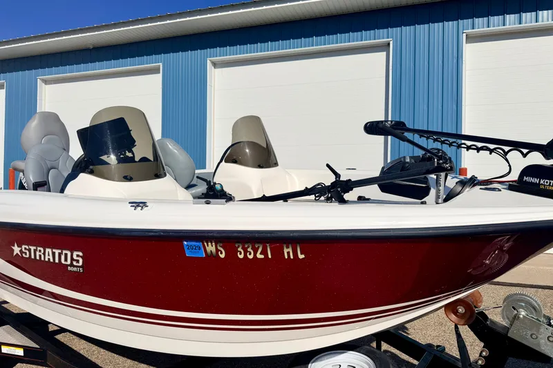 Slide: The Image of 2007 Stratos 375 XF boat with red hull, parked near blue building. - 15