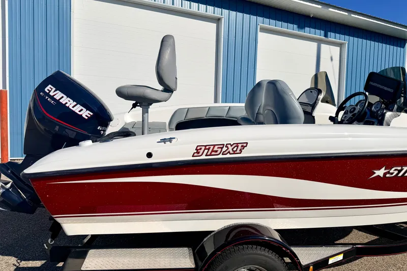 Slide: The Image of 2007 Stratos 375 XF boat with Evinrude engine, parked near blue building. - 16