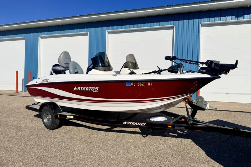 The Image of 2007 Stratos 375 XF boat on trailer, parked outside blue building. - 0