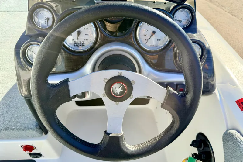 Slide: The Image of Steering wheel and dashboard of a 2007 Stratos 375 XF boat, featuring gauges and controls. - 42