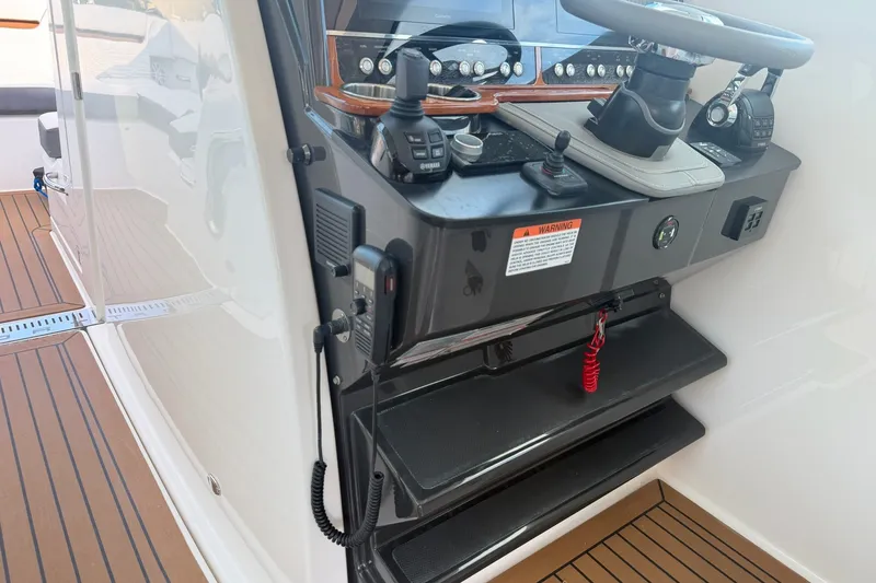 Slide: The Image of 2020 Tiara Sport 34 LX helm with steering wheel and controls on teak deck. - 28