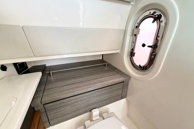 Slide: The Image of 2020 Tiara Sport 34 LX boat interior with sleek cabinetry and porthole window. - 34