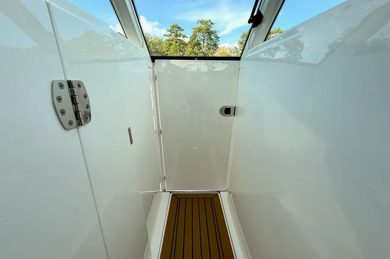 Slide: The Image of 2020 Tiara Sport 34 LX boat interior with sleek white walls and wooden flooring. - 37
