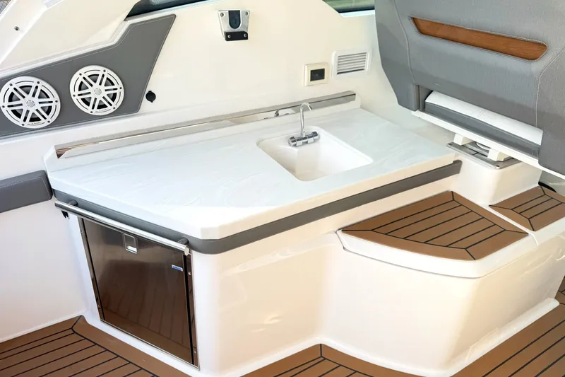 Slide: The Image of 2020 Tiara Sport 34 LX boat interior with sink, speakers, and seating area. - 18