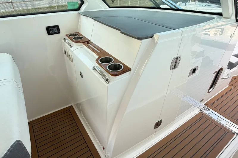 Slide: The Image of Interior of 2020 Tiara Sport 34 LX boat with cup holders and wooden flooring. - 29