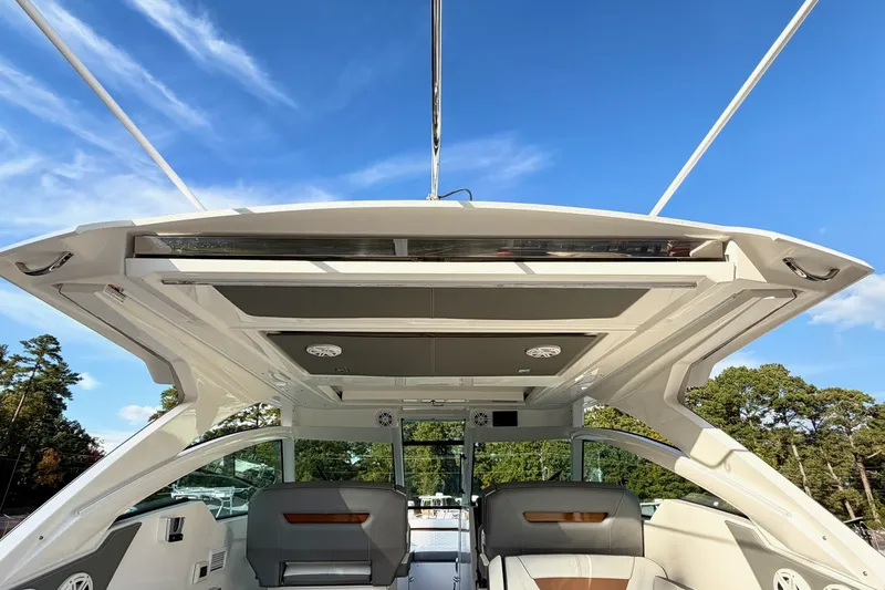 Slide: The Image of 2020 Tiara Sport 34 LX boat interior with open roof, showcasing sleek design and seating. - 12
