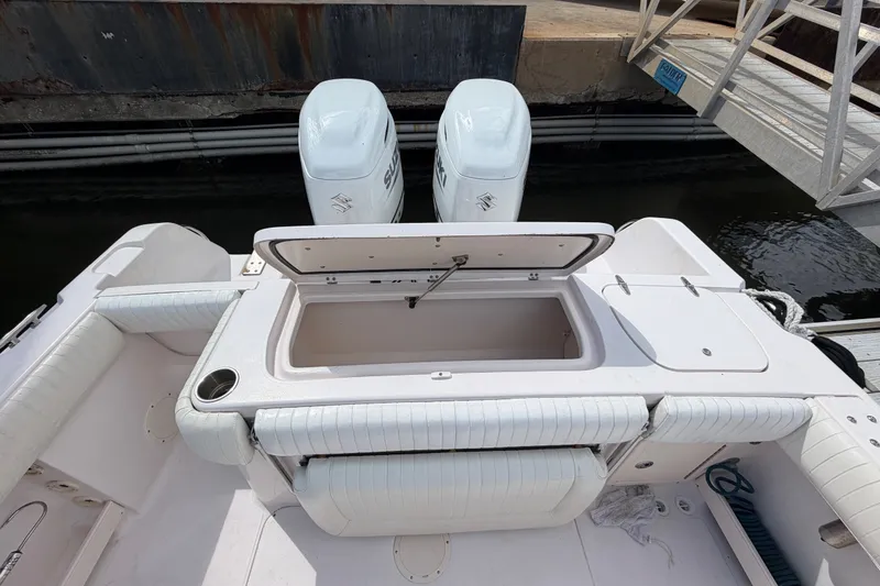 Slide: The Image of 2002 Grady-White Release 283 boat with open storage compartment and twin Suzuki engines. - 9