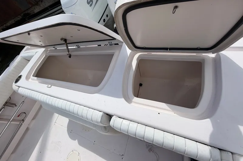 Slide: The Image of Two open storage compartments on a boat with white upholstery and an engine in the background. - 10