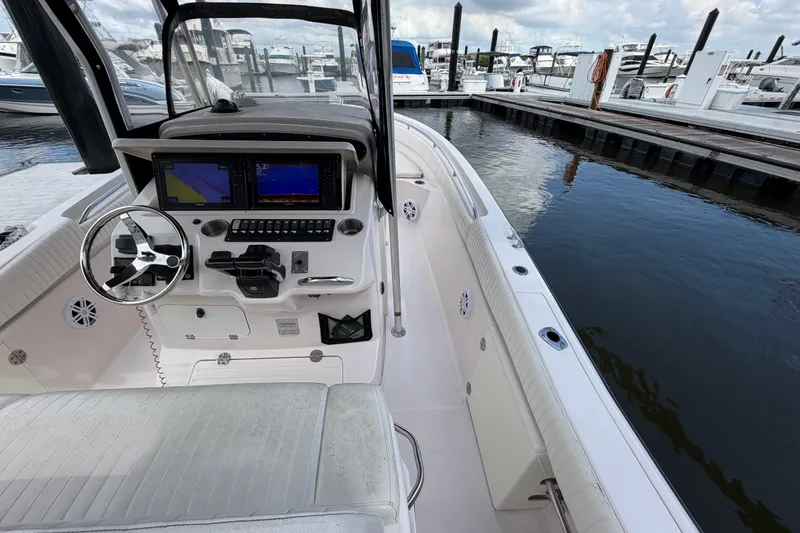 Slide: The Image of 2002 Grady-White Release 283 boat interior at marina, featuring helm and navigation screens. - 12