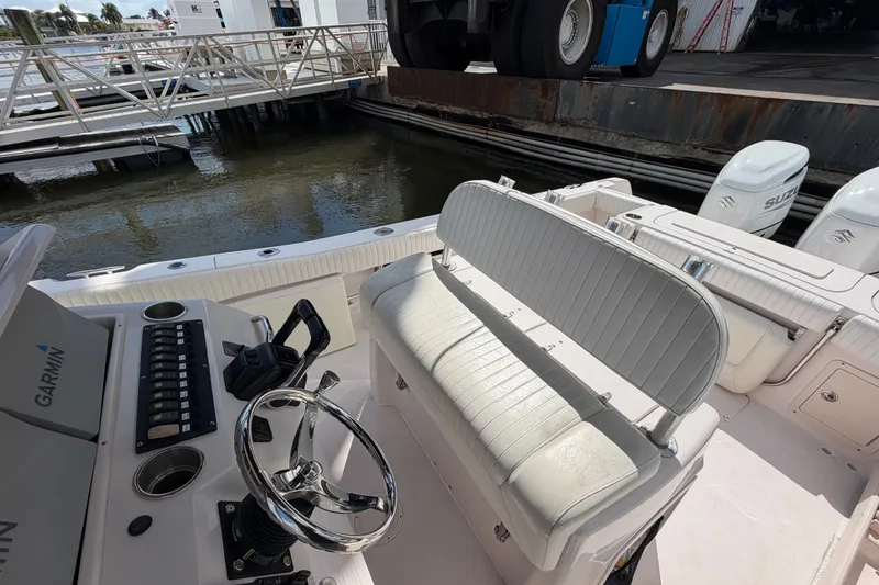 Slide: The Image of 2002 Grady-White Release 283 boat interior with steering wheel and seating, docked near water. - 14