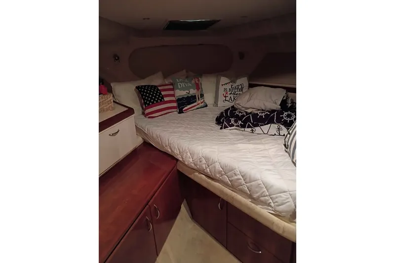 Slide: The Image of Cozy cabin interior of 2003 Carver 350 Mariner with nautical-themed bedding and pillows. - 5