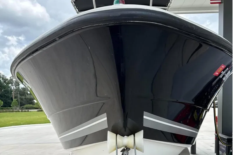 Slide: The Image of 2008 Triton 225 CC boat with sleek black hull at a dockside view. - 6