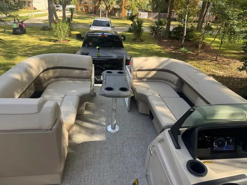 Slide: The Image of The image shows the interior of a Bennington 22 SSRX pontoon boat with beige seating and a table. - 15