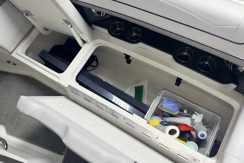 Slide: The Image of 2019 Formula 350 Crossover Bowrider I/O storage compartment with cleaning supplies and cup holders. - 28