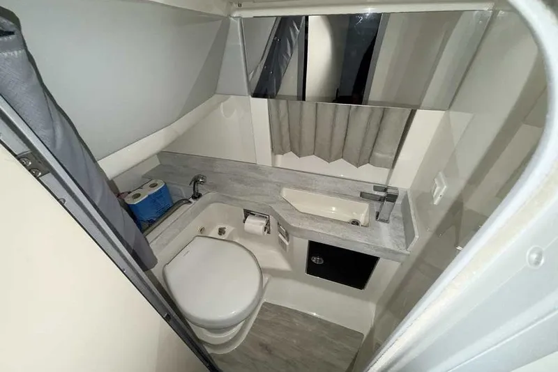 Slide: The Image of 2019 Formula 350 Crossover Bowrider I/O bathroom with toilet, sink, and storage. - 40