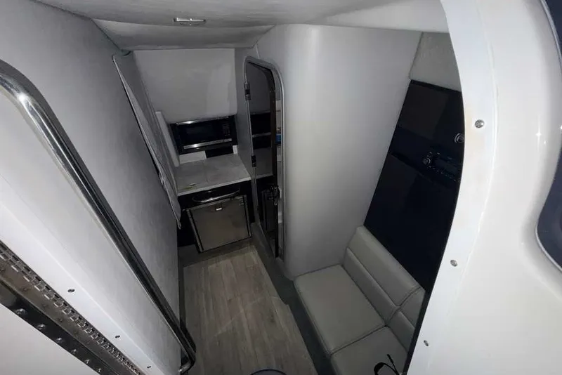 Slide: The Image of Interior of 2019 Formula 350 Crossover Bowrider I/O, featuring compact kitchenette and seating area. - 32