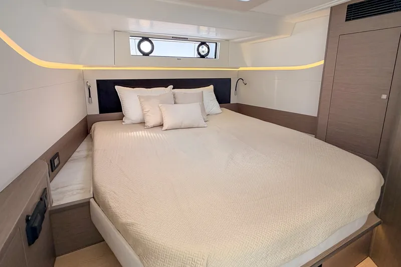Slide: The Image of Das Bild zeigt eine luxuriöse Kabine mit einem großen Bett, eleganter Beleuchtung und modernen Details. - 10