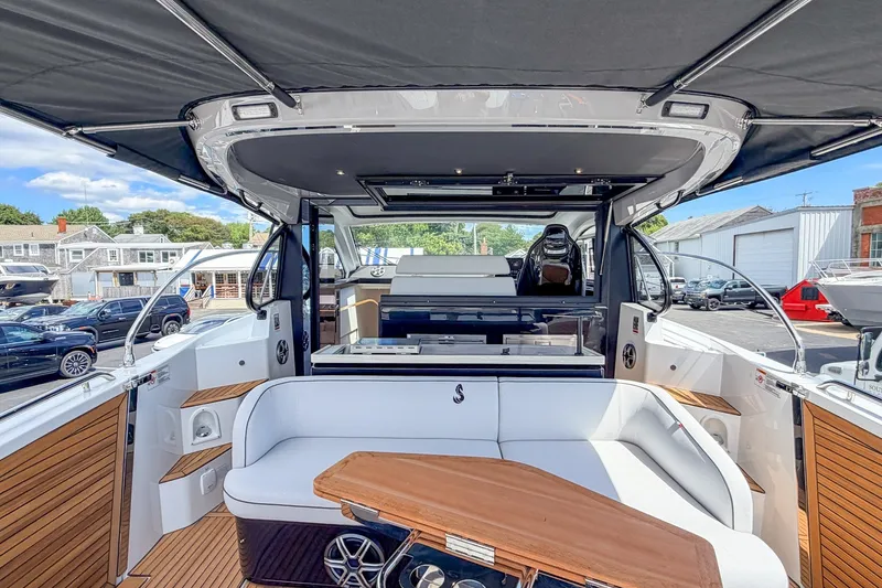 Slide: The Image of Das Bild zeigt das Cockpit einer Beneteau Gran Turismo 40 mit eleganten weißen Sitzen und einem Holztisch. - 8