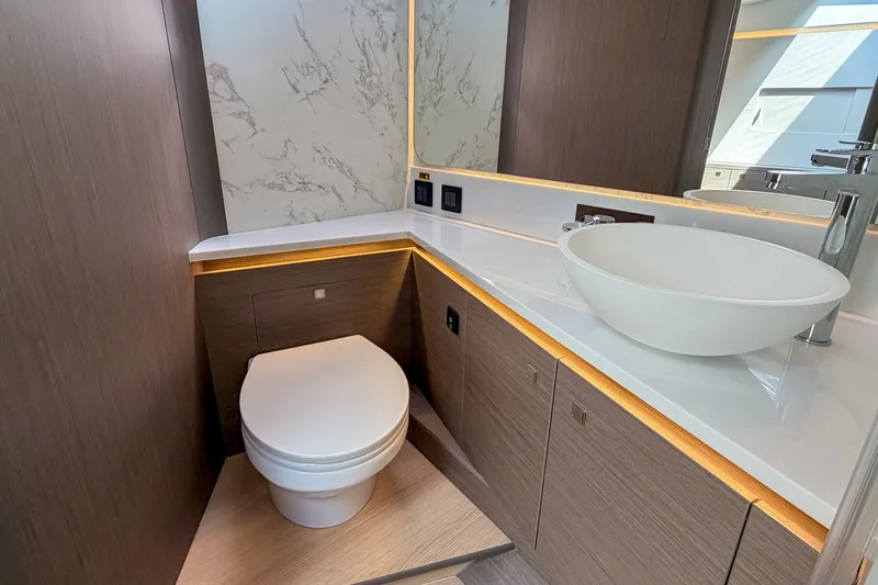 Slide: The Image of Das Bild zeigt ein modernes Badezimmer auf einem Boot mit einer eleganten weißen Waschschüssel und Holzverkleidung. - 11